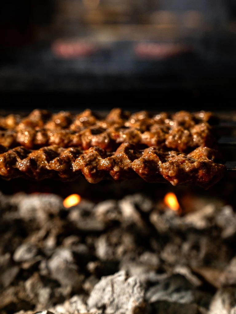 A sliced ribeye and smash burger served under warm industrial lighting at DNA Rock Cafe