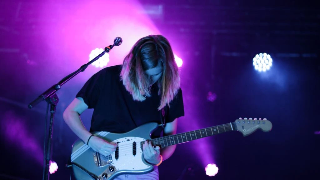 Blues guitarist performing under a single spotlight